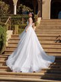 Gorgeous bride in Moonlight Couture H1587 a luxurious wedding dress featuring V-neckline, pleated bodice, 3D florals, A-line skirt, and chapel train on steps