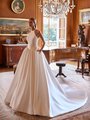 Bride in an elegant halter Mikado ball gown wedding dress with pockets, exuding elegance in a beautifully adorned room Moonlight Couture H1602