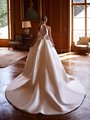 Bride in a luxurious halter keyhole back Moonlight Couture H1602 Mikado wedding dress adorned with a bow, radiating elegance in a refined setting 