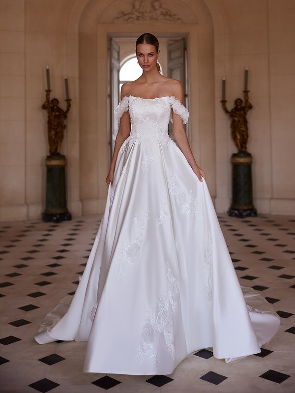 An exquisite bride dons an off-the-shoulder satin ball gown, highlighted by delicate 3D floral and lace accents Moonlight Couture H1608