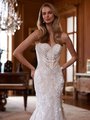 A close-up of a bride wearing an elegant strapless wedding gown with a sweetheart neckline. The bodice is adorned with intricate lace embroidery, floral appliqués, and delicate pearl-like beading that accentuates her waist. The dress's fitted design highlights her figure.