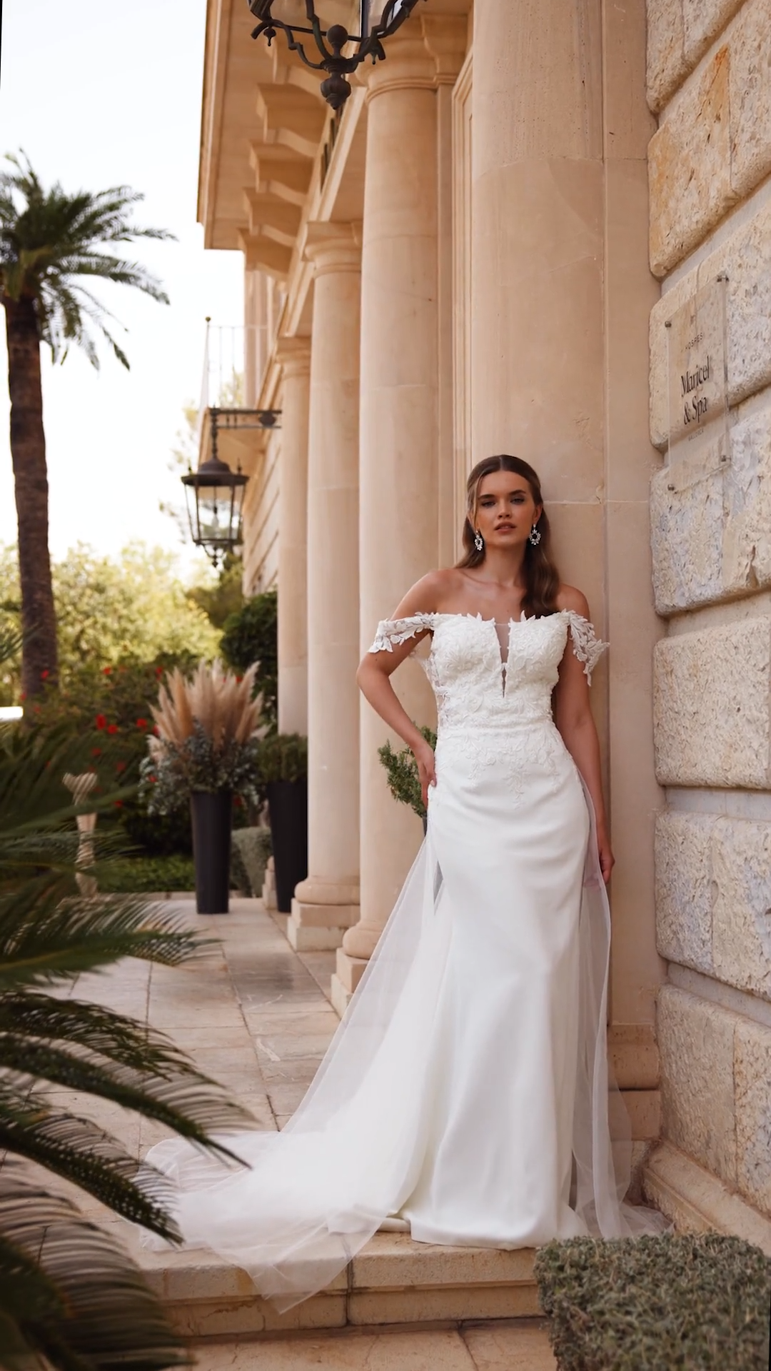 Bride wearing a 2-in1 off the shoulder crepe wedding dress with detachable tulle train