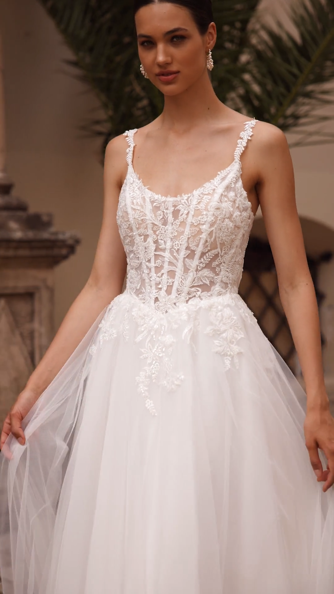 Bride in a tulle wedding dress with vine lace illusion bodice and Basque waistline